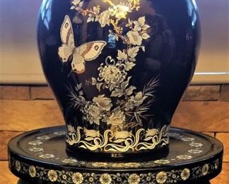 Black lacquer inlaid decorative scenes on vases and round table top/stands and furnishings. 
