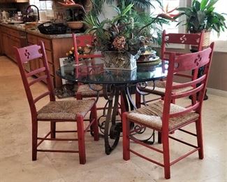 Heavy duty round glass dining table top. Can also be used outdoors. It has a metal base. 4 red chairs.