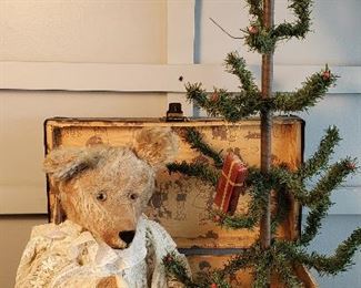 antique teddy bear in old toy trunk with Christmas tree