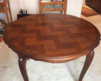 Patterned round wood table with two leaves.