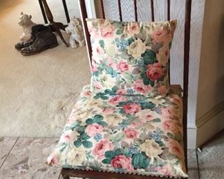 Metal chair with floral pillows.