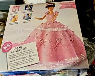 Barbie cake mold and 2 waist up Barbie's in contents.