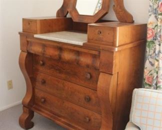 74. $300.00. American Empire projection front dresser. Cleval style mirror. Marble surface well area with two glove boxes. 68” X 42.5” X 20” Circa 1860. Note: veneer lifting in next picture.