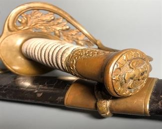 A deluxe grade U.S. Model 1852 U.S. Naval Officer's sword with a Klingenthal blade assembled / retailed by E. Leon, Paris. Deeply etched blade is in very nice condition, with standard m1852 pattern motifs of an American Eagle, Fouled Anchor and U.S.N. in a banner to the left side. Right side bears anchor topped with a Federal Shield and an oval panel consisting of 33 stars. Ricasso measures 1.15" and is correctly stamped with inspector marks of crown "B" and shield "S". Spine is engraved with Klingenthal marking and hilt is stamped on under side of guard with "E. L. with 3 stars" (mark of E. Leon, an assembler and retailer of swords located in Paris). Grip is excellent with a white rayskin grip and original double strand wire wrap. Blade measures 29” and sword has an overall length of 33”. Scabbard is leather, complete with matching throat, middle band and drag bearing sea monster. The rare scabbard is a correct French top stitched scabbard. Note scabbard has a partial break near the