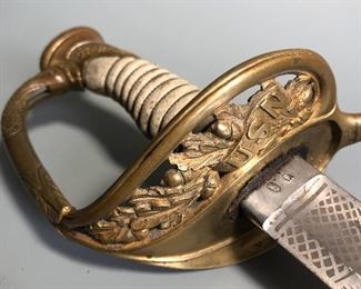 A deluxe grade U.S. Model 1852 U.S. Naval Officer's sword with a Klingenthal blade assembled / retailed by E. Leon, Paris. Deeply etched blade is in very nice condition, with standard m1852 pattern motifs of an American Eagle, Fouled Anchor and U.S.N. in a banner to the left side. Right side bears anchor topped with a Federal Shield and an oval panel consisting of 33 stars. Ricasso measures 1.15" and is correctly stamped with inspector marks of crown "B" and shield "S". Spine is engraved with Klingenthal marking and hilt is stamped on under side of guard with "E. L. with 3 stars" (mark of E. Leon, an assembler and retailer of swords located in Paris). Grip is excellent with a white rayskin grip and original double strand wire wrap. Blade measures 29” and sword has an overall length of 33”. Scabbard is leather, complete with matching throat, middle band and drag bearing sea monster. The rare scabbard is a correct French top stitched scabbard. Note scabbard has a partial break near the