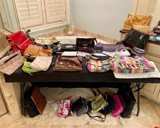 Table full of designer purses and handbags 