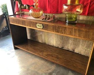 $280. 54" w x 16 d x 27.5 tall. Campaign style console / sideboard. would be great media piece, or bar. in great shape. very nice corner accent brass hardware. the top is thatched and then has a glass piece covering it, that is inset. 