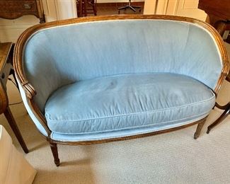$225; Louis XVI style velvet single cushion carved sofa with wrap around back; 33" H x 54" W x 25" D, seat height is approximately 19.5". As is, stains on cushion.