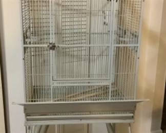 #130) $100 NOW 20% (was $125) Vintage Steel Parrot Birdcage. Cool Design. Cage opens at the top. Pull out drawer and screen.  Light green on wheels. Food holders swing out for refilling. Approx 64” x  26” x 20”. Legs are approx 2 feet tall. Does not collapse but legs come off.(1 of 2 views) 