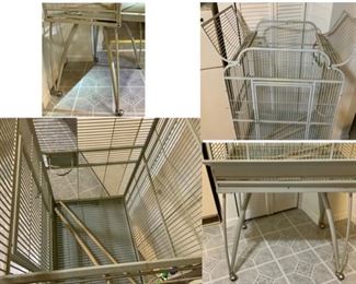 #130) $100 NOW 20% OFF (was $125 ) Vintage Steel Parrot Birdcage. Cool Design. Cage opens at the top. Pull out drawer and screen.  Light green on wheels. Food holders swing out for refilling. Approx 64” x  26” x 20”. Legs are approx 2 feet tall. Does not collapse but legs do come off. (1 of 2 views) 