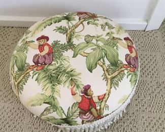Small footstool with monkey pattern fabric.