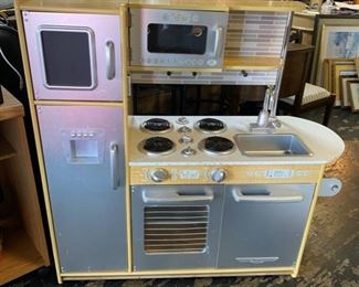 "KIDKRAFT Uptown Espresso Kitchen" with play refrigerator, freezer, oven, microwave, removable kitchen sink, and made of a sturdy wood construction with a speckled-type countertop. Measurements: Width 43" x Depth 18" x Height 41"
