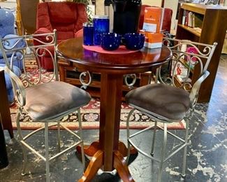 High Top Round Wooden Table with 2 Metal Swivel Chairs, as well as a KUREG Coffee Machine and Blue Glass COFFEE & Sugar Dispenser