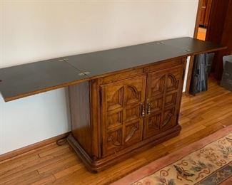 $100 Sideboard Server Buffet Cabinet.  Top opens out to full 76”w with black protective top finish. Measures 38w 18d 32h when closed.  Bottom cabinet has a drawer.  Great piece!  Thomasville.  See other listing for coordinating dining table and wall unit china storage.