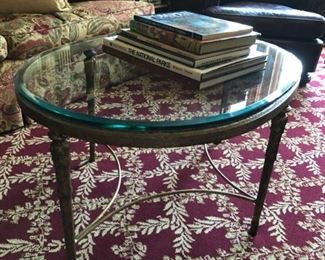 Oval glass-top cocktail table. Measures 27" W x 36" L x 19"H.