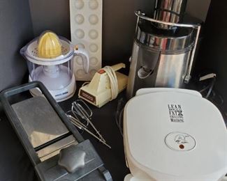 https://ctbids.com/#!/description/share/687845 Assorted small kitchen appliances. Includes a Sharper Image juicer, George Foreman Grill, Mandoline slicer, vintage Hamilton Beach handmixer, Black and Decker electric juicer and a 2 piece ravioli maker.