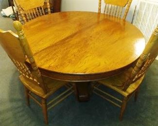 Antique Round Oak Pedestal Table with 6 Pressed Back Chairs and 2 Leaves .