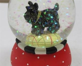 Michel and Co mini snow globe with Scottie dog figure.  Says woof woof woof around the base.  2.5" tall 
