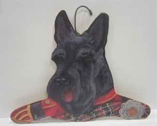 A door skin type wood cut out and covered with a paper creating a clothes hanger.   Scottie dog image by Annie Starbarrack.  16.75" wide
