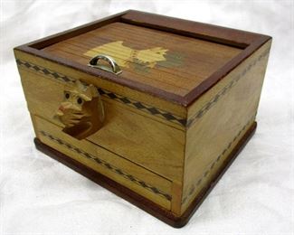 A vintage Japanese wood cigarette box with Scottie dog motif. Pull back the tambour lid on the top, and the bottom drawer opens and an arm mechanism hands up a cigarette.  4.5" wide, 2.75" tall