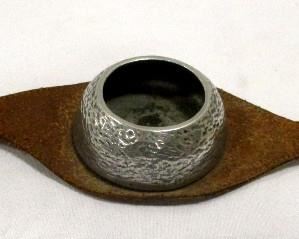 A vintage leather over the arm ashtray.  Has aluminum tray in the center, and a dog face finial/weights on each side.  A hound and Scottie.   12" long
