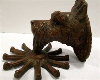 A vintage wall mount Scottie dog tie holder with spinning wheel.  Made of a composition material, likely Siroco Wood.  5" tall, 6.5" deep

