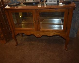 Beautiful Sofa Style Display Cabinet of Solid Oak with Mirrored Back, Glass Shelving plus Figurines and Collectibles are displayed on top.