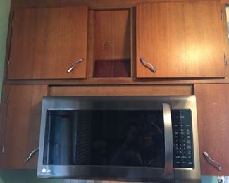 Microwave and vintage wood cabinets.