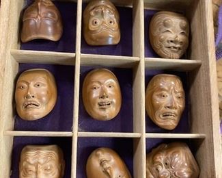 Set of 27 miniature Japanese wooden masks in box with paperwork.