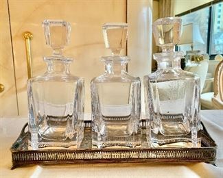$400 - Set of Three Baccarat Crystal Square Decanters and Silverplate Tray; as is, two decanters have chips in the mouth. 9” H x 4” W, tray is 14.5” x 6.5”. 
