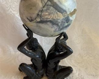 $75 - Marble sphere supported by two cast metal figures; 8" H x 5.5" W