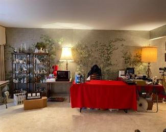 Living room and cash out. Load are on large table to left. Sterling flatware on table with lamp. Vintage cameras on table to right. 