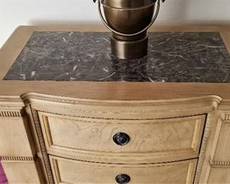 View of top of light colored night stand/side table with black marbled inset.
