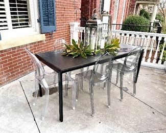 Outside table with set of ghost chairs
