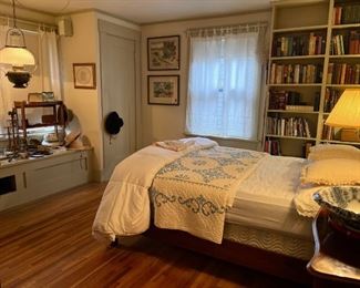 Bedroom view with many books, antique dresser and bed and Victorian oil lamp conversion