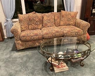 Two nice comfy couches, 2 oval glass & iron base coffee tables, and several nice coffee table books.