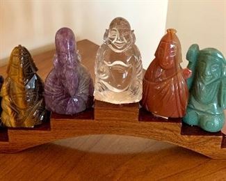 Decorative Buddha Sculpture features seven different Buddha figurines in a variety of materials including quartz, and other stones. Measures 11" x 5" 