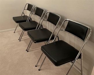 Set of Four Chrome and Faux Leather Folding Chairs.  Two of the chairs have rips in the seats. Standing open, the chair's heights are 29" and the seats measure 15" x 15" with the back width of 18" 