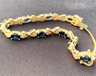 14k and Sapphire Tennis Bracelet. Features a safety chain and slide clasp. A very beautiful bracelet. Inside diameter is about 2.75" and weight is 20.13 grams. 