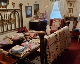 Lots of old quilts,, beautiful queen brass bed, ornate metal mirror, magazine rack, baby doll cradle, antique dolls, large antique armoir. Pink statue in right rear corner is sold. Stained glass window on floor by window is sold.