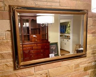 Lot 4822.  $425.00   Beautiful, Ginormous embellished, beveled mirror in perfect condition.  The frame is in antique gold and black.	46" H x 70" L. Super well-crafted - we would presume it's quite heavy.  We were afraid to remove it from the wall at this point due to the size and weight.  This would be an ideal piece to help make a room look larger than it is.  