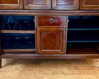 Lot 4834. $1195.00  Hooker Entertainment Cabinet, purchased at Walter E. Smithe and one of the nicest cabinets we've ever seen in the 20+ years of hosting estate sales!  Currently holds a 55" TV. Room for up to a 60".  Dark Wood and beautifully crafted - Hooker just shines at the construction of cabinet furniture, office furniture, desks and more. Measures 82" tall x 24" deep x 62" long. Check out the photos for an even better description. Excellent Condition.  Cabinet doors retract and disappear. The Lower Cabinet has 2 Doors that can be reversed for clear glass and center cabinet is for a speaker.
