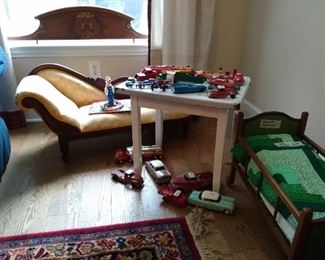Antique doll bed, chaise lounge, enamel child's table, antique and vintage Tootsietoy, Hubley, and Wyandotte cars
