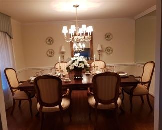 Dining Room - table and chairs, flowers, candleholders, china and stemware, wall mirror, lamps and decorative plates.  Oil paintings of fruit (not shown in picture)