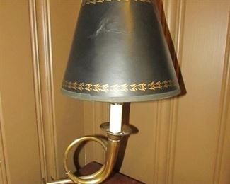 •	Item 5: Small brass trumpet form table lamp with black parchment clip on shade. Shade is dented. 8”wide x 15.5”tall x 8”deep. PRICE: $12.00