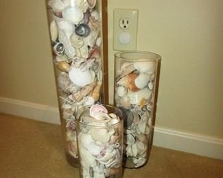 •	Item 40: Set of (3) vases filled with seashells. Height of tallest is 18” and 4.75” diameter. PRICE FOR THREE: $35.00