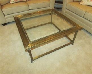 •	Item 66: Brass and beveled glass cocktail table. Some tarnishing and oxidizing present. 36” square x 16” tall. PRICE: $95.00