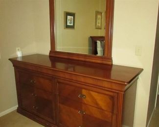 •	Item 69: Dresser with wood grain (compressed wood construction) and beveled mirror. Nicks to base at front. 70.5” wide x 21.5”deep x 79” tall. PRICE: $150.00