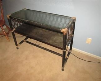 •	Item 93: Rattan console table with glass top. Some wear to finish. 39”wide x 18”deep x 30” tall. PRICE: $75.00