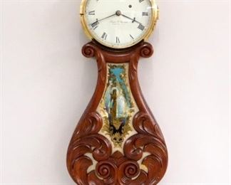 A 1971 Elmer O. Stennes Lyre Banjo clock. 8-day weight driven time only movement marked "E O Stennes, Weymouth, Mass. 70" painted metal dial with Roman numerals marked "Elmer O. Stennes, Weymouth, Mass", cast iron weight with Stennes mark. Mahogany case with carved lyre throat and reverse painted glass, marked "14" for the 14th clock made after Stennes was imprisoned, "71" for 1971 and "M. C. I. P." for Massachusetts Correctional Institute, Plymouth, with additional Stennes brand on backboard. This clock is in very good condition without repair and was running when cataloged. 42 1/2" high overall. ESTIMATE $2,000-3,000